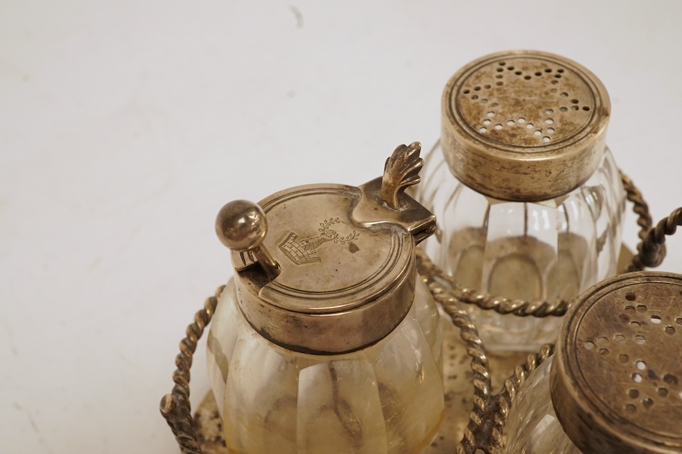 A late Victorian silver small cruet stand, with three mounted glass bottles, all Hukin & Heath, Birmingham, 1897, one associated bottle London, 1891, diameter 10.9cm, together with three assorted silver napkin rings, a s